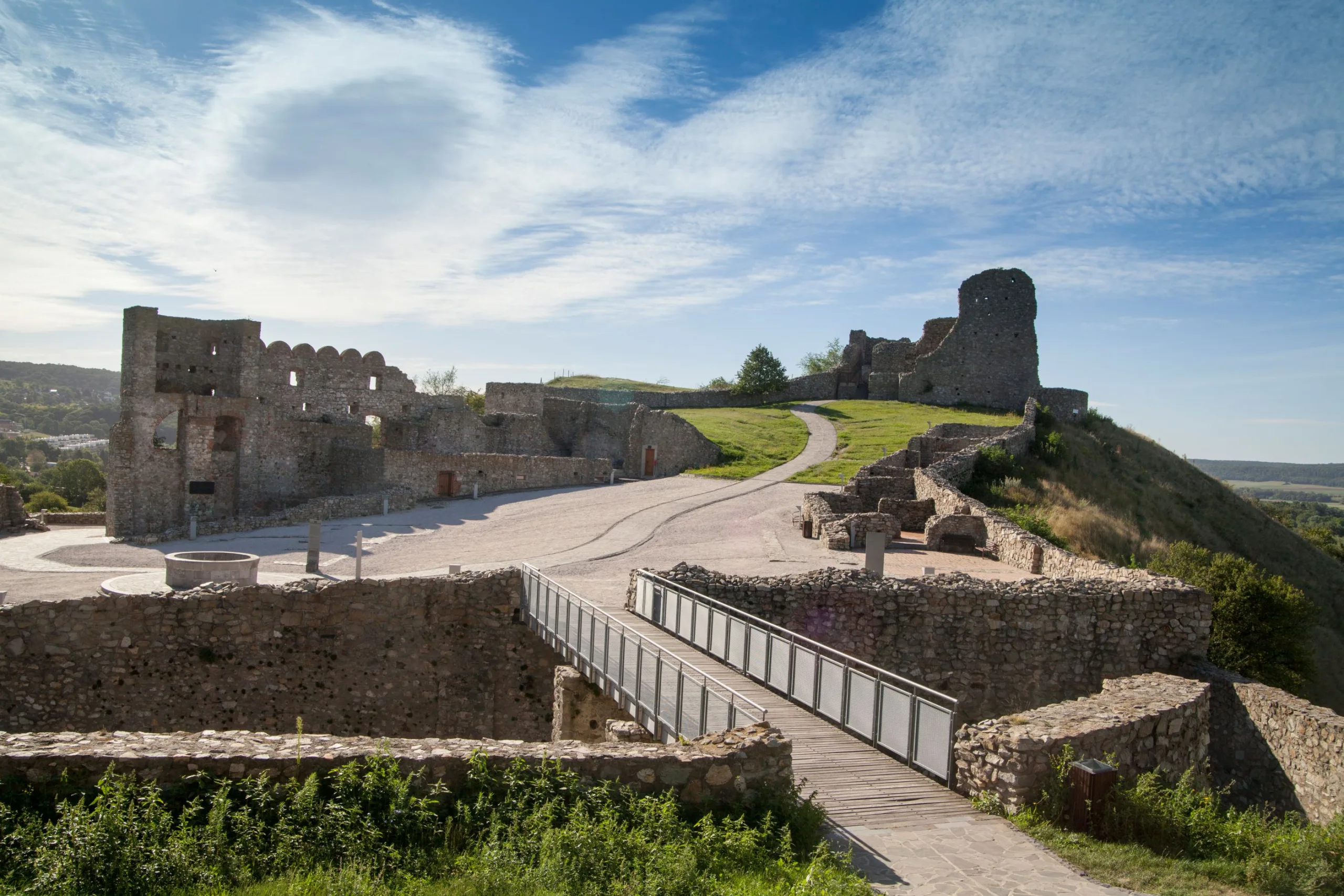 The stone ruins of Devín Castle on their hilltop outside Bratislava, the curtain walls and a round bastion standing against a blue sky.
