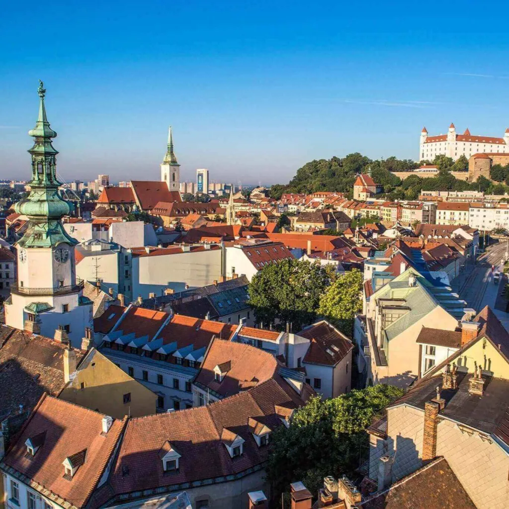 Bratislava's old town from above, with the green tower of St Michael's Gate, the spire of St Martin's Cathedral and Bratislava Castle on the hill behind.