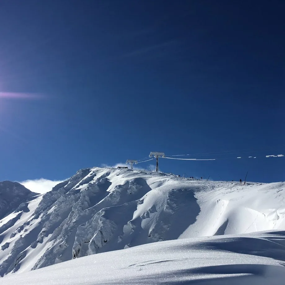 The snow-covered summit ridge at Jasná in Slovakia's Low Tatras under a clear winter sky.
