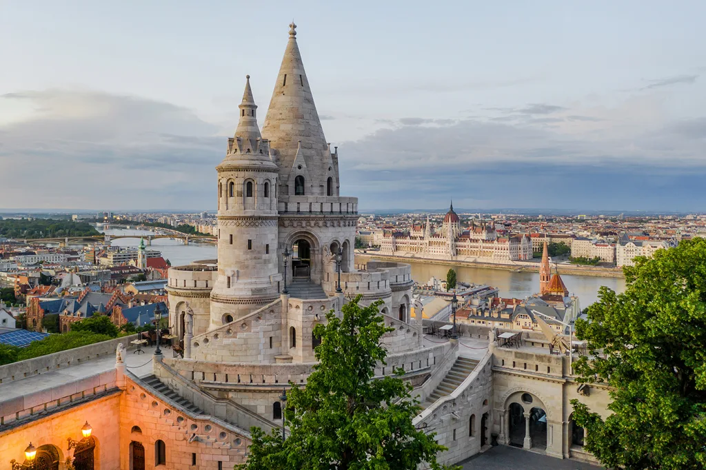 Fisherman's Bastion in Budapest at dusk, looking across the Danube to the Hungarian Parliament.