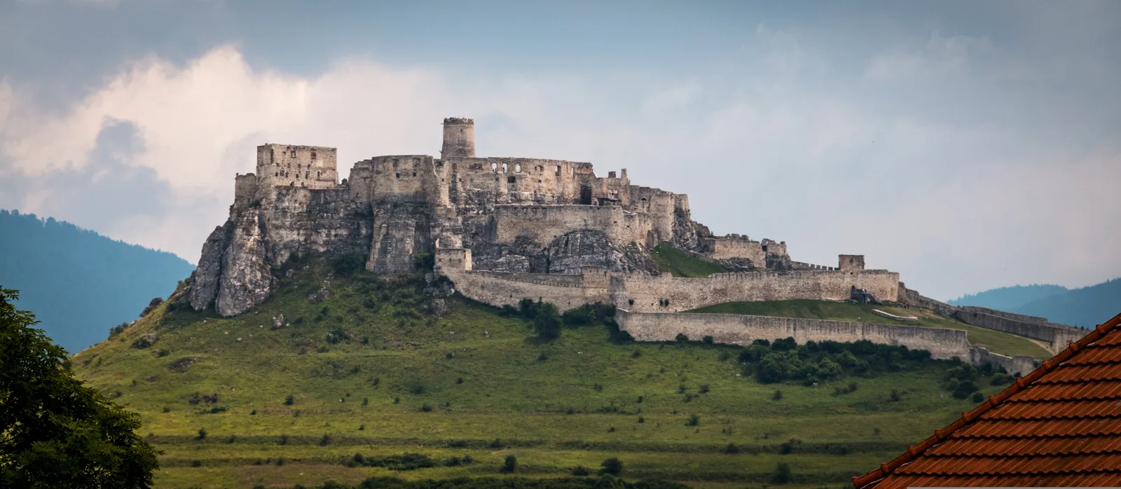 Spiš Castle on its limestone ridge above the Spiš plain, one of the largest castle complexes in Central Europe.