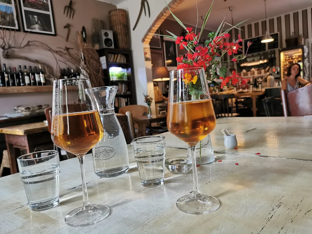Four glasses of rosé poured for a tasting on a wooden table in a Small Carpathian wine shop.