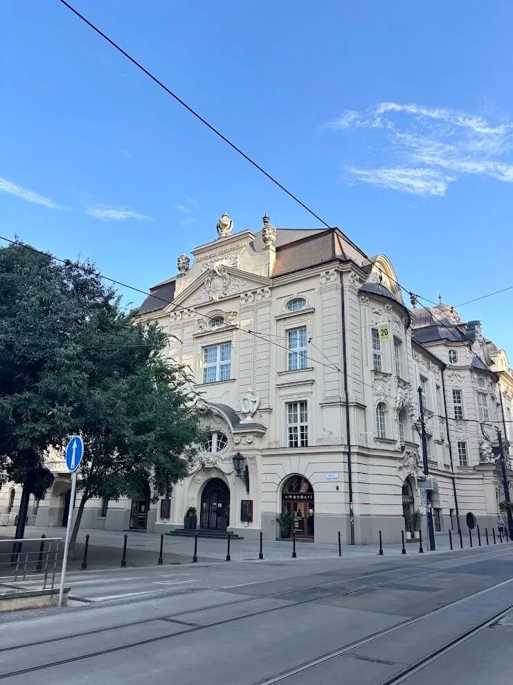 Das Gebäude der Reduta in Bratislava, Sitz der Slowakischen Philharmonie, mit Straßenbahnschienen, die an der neobarocken Fassade vorbeiführen.