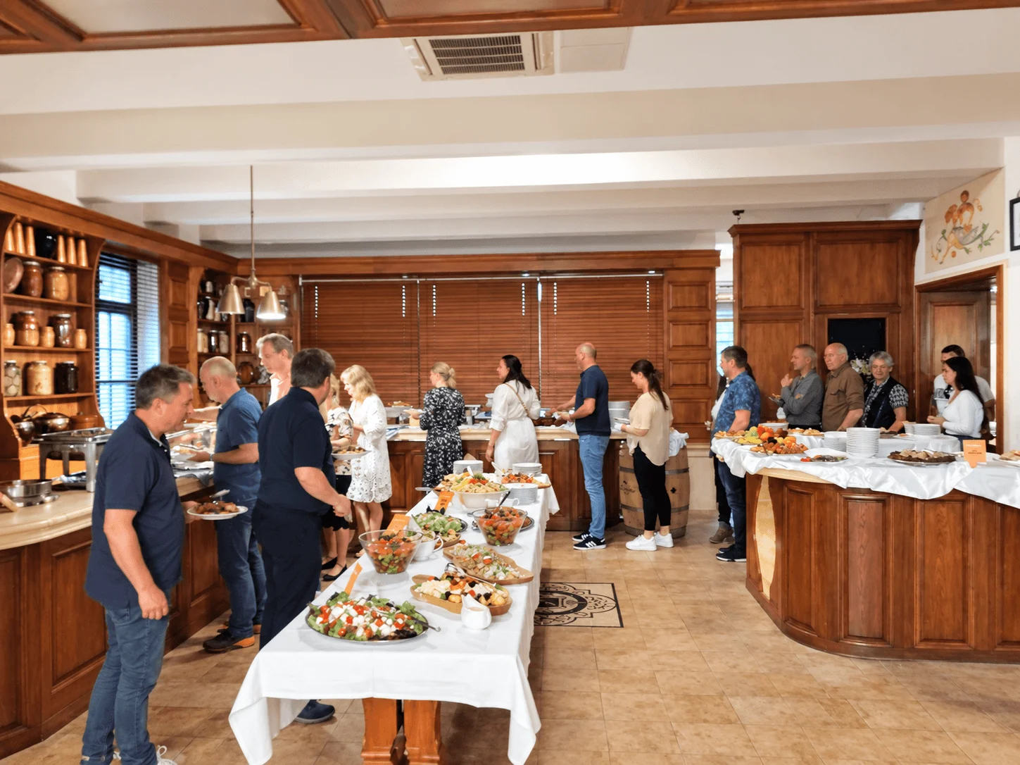 A group helping themselves at a buffet lunch in a wood-panelled restaurant in Bratislava.