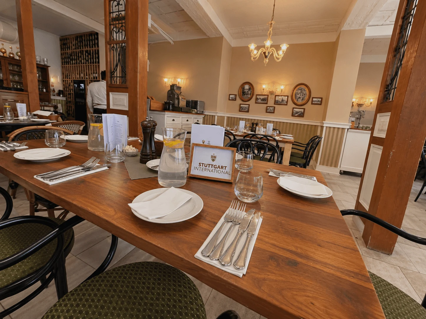 A long table set for a group lunch at Zylinder Café in Bratislava, with a reserved-table sign among the place settings.