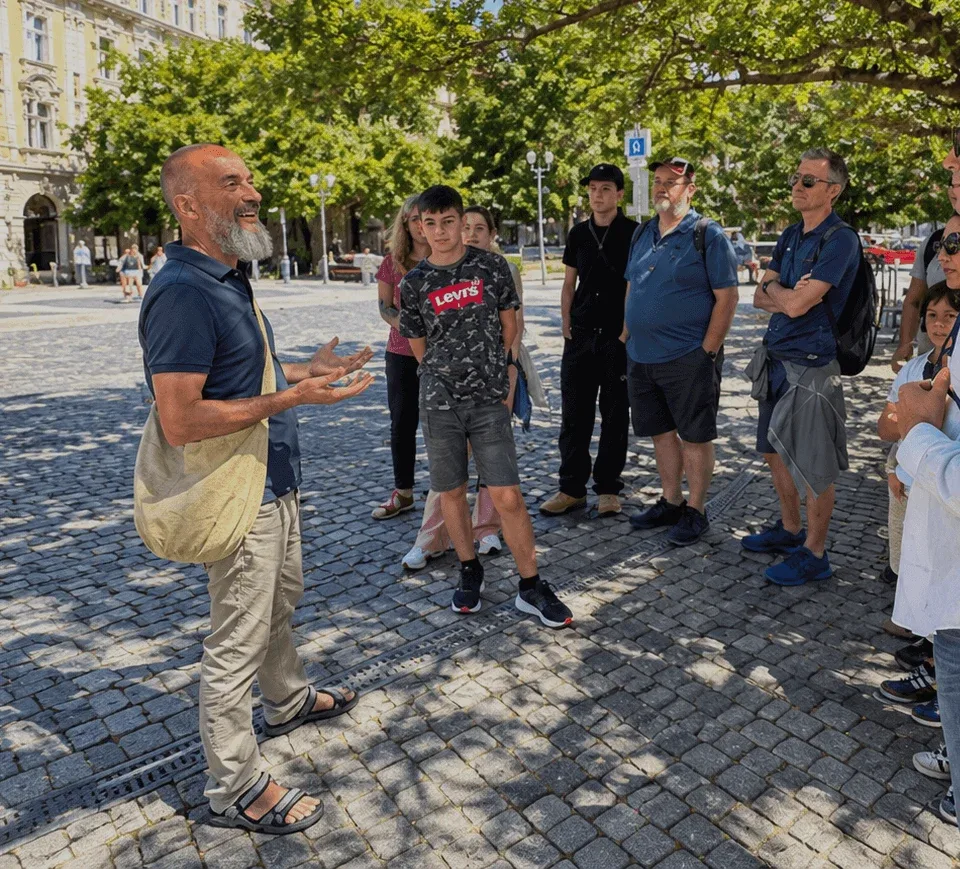 A local guide leading a walking tour for a small group on a tree-shaded square in Bratislava’s Old Town.