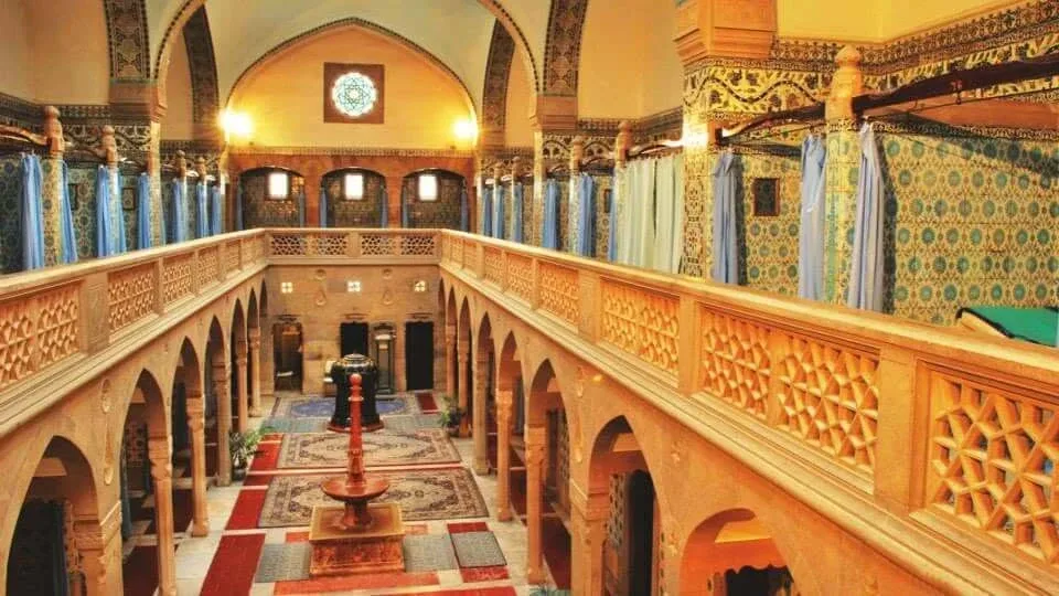 Inside the Moorish-style Hammam bathhouse in Trenčianske Teplice, with carved galleries, tiled walls and a central fountain.