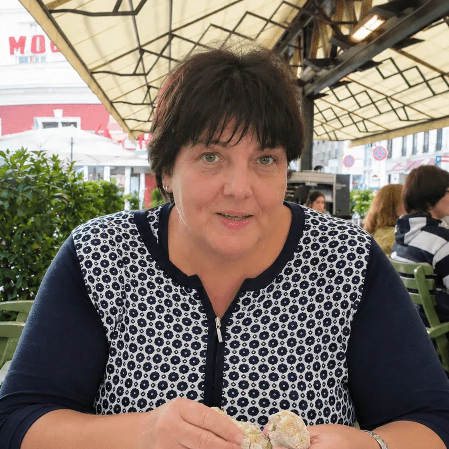 Gabriela, co-founder of E-TRAVEL.SK, at a café terrace table under an awning.