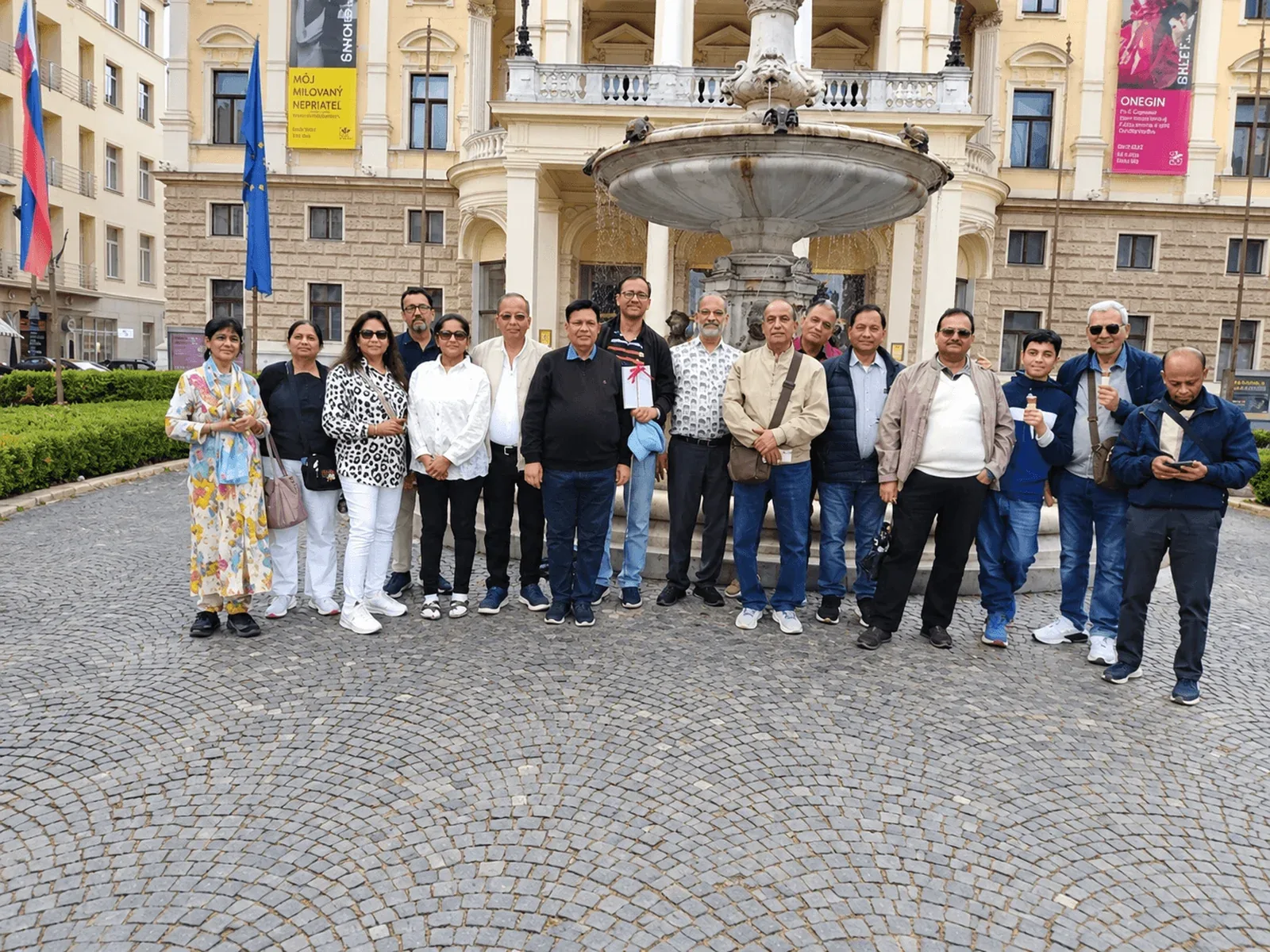 A tour group photographed in front of the fountain outside the historic Slovak National Theatre building in Bratislava.