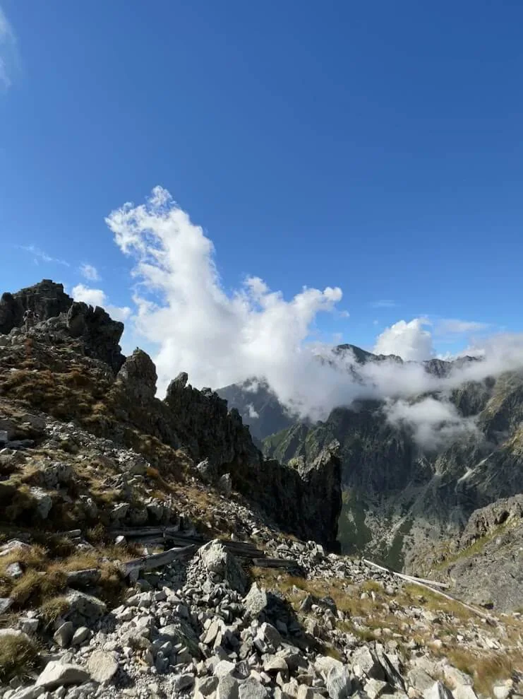 Cloud spilling over a rocky ridge in the High Tatras, the valley falling away into shadow below.