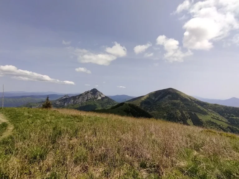 A grassy ridge in the Malá Fatra with the rocky peak of Rozsutec and a rounded summit beyond.