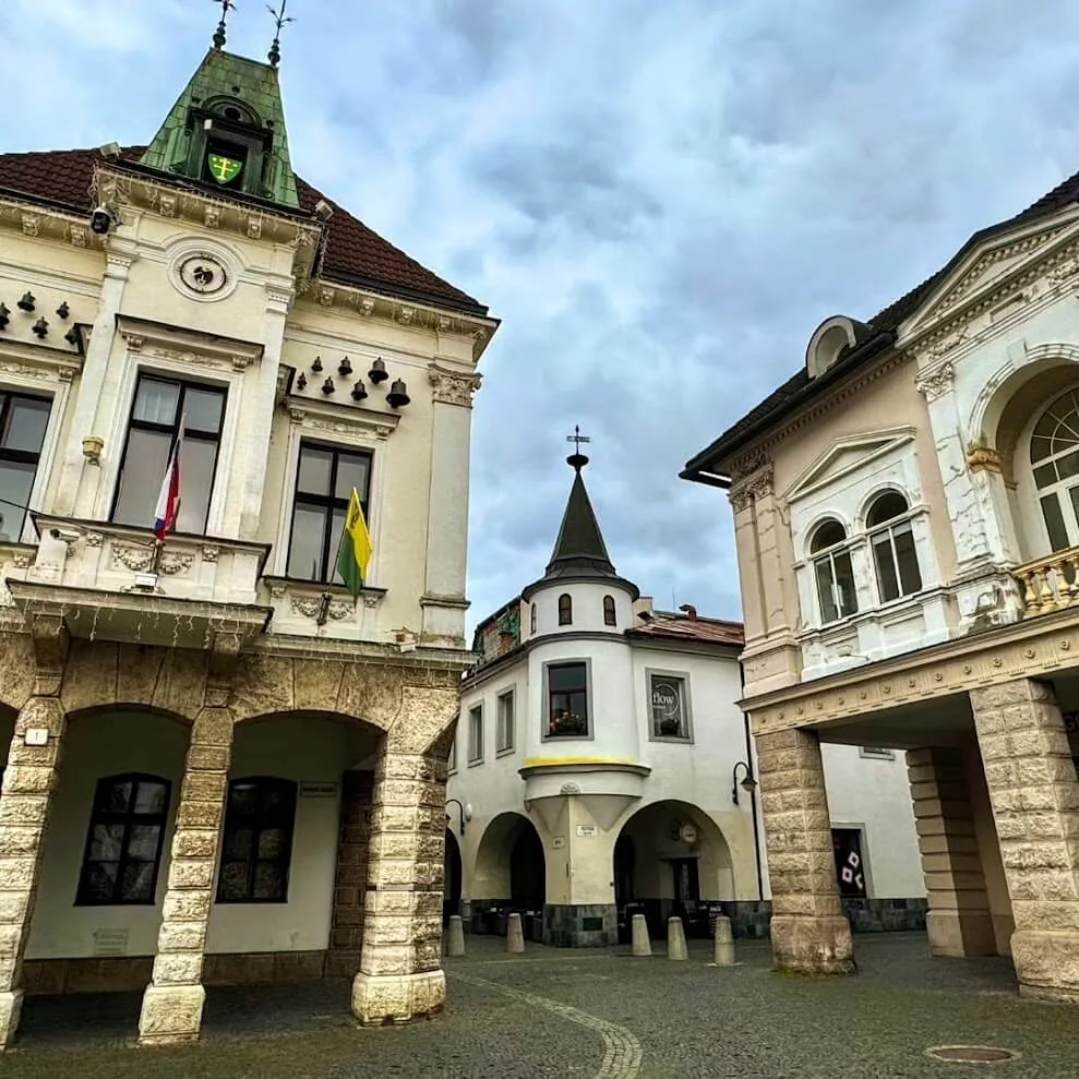 Mariánske námestie, the arcaded main square in Žilina, its burgher houses and corner turret under a grey sky.